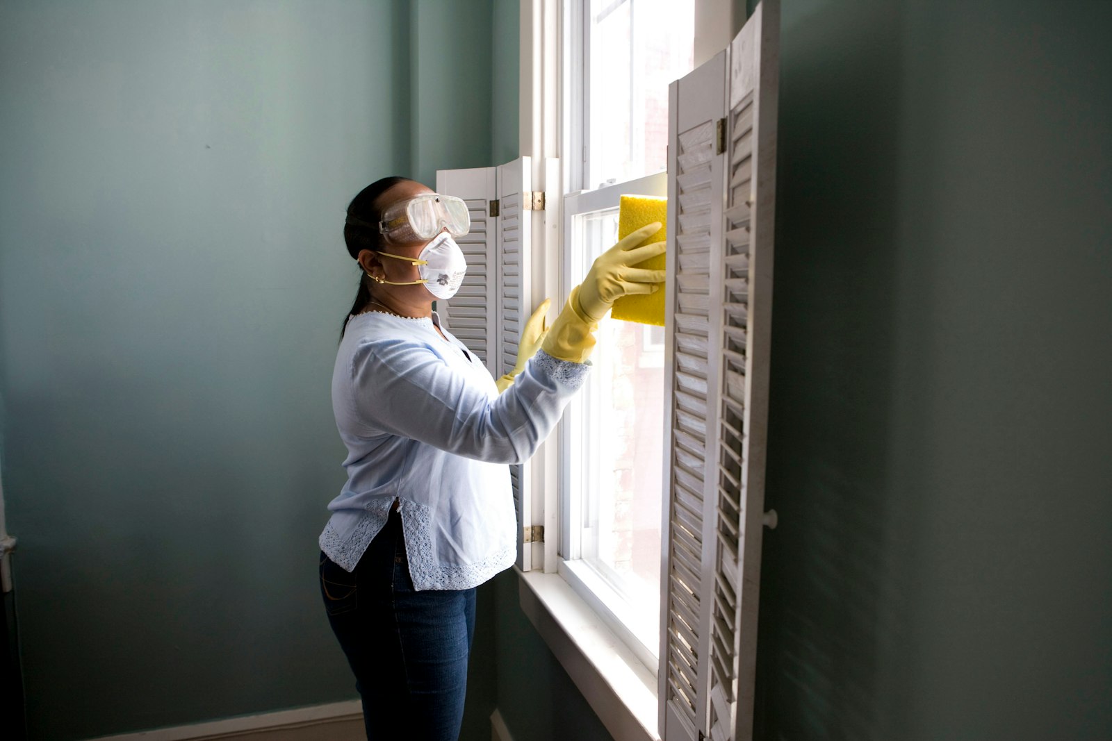 Hand mit Fensterabzieher reinigt eine Glasscheibe — Detailbild Glas- und Fensterreinigung
